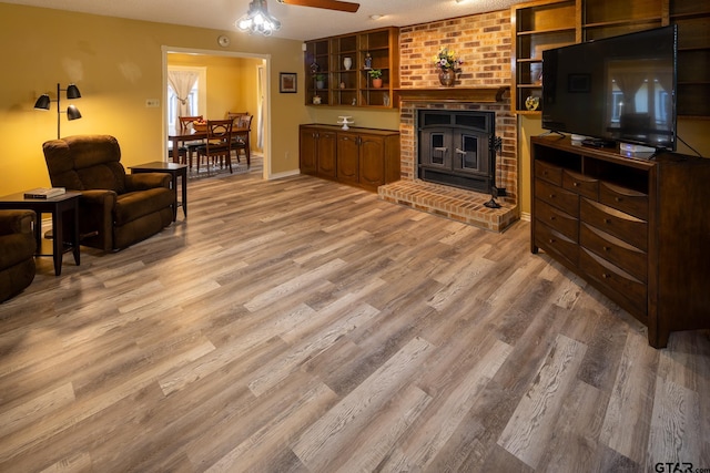 living room with hardwood / wood-style flooring, ceiling fan, and a fireplace