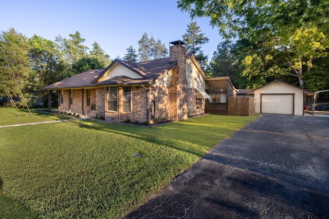 view of front facade featuring an outbuilding, a garage, and a front lawn