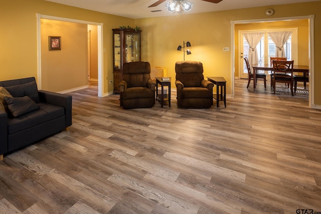 living room featuring hardwood / wood-style floors and ceiling fan