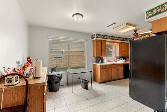 kitchen featuring ornamental molding, black fridge, and light tile patterned flooring