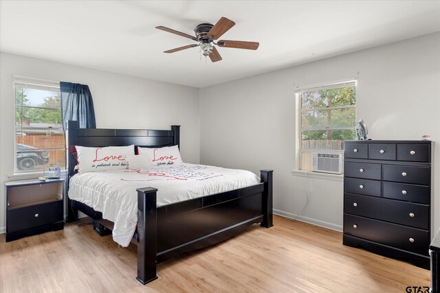 bedroom featuring multiple windows, ceiling fan, and light hardwood / wood-style flooring