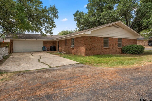 ranch-style house featuring a garage and a front yard