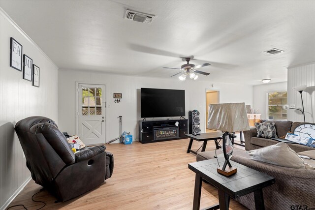 living room with ceiling fan, light hardwood / wood-style floors, and crown molding