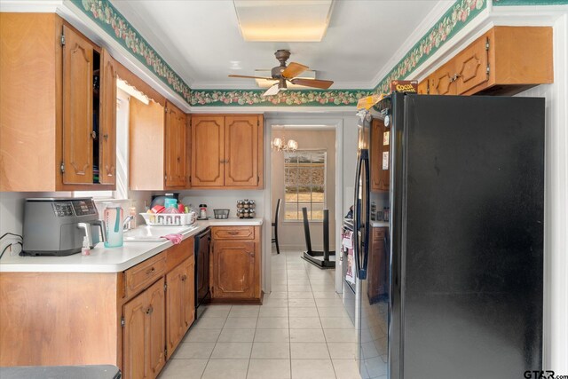 kitchen featuring sink, black appliances, ornamental molding, ceiling fan with notable chandelier, and light tile patterned floors