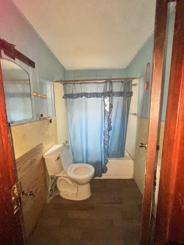 full bathroom featuring a shower with curtain, toilet, a textured ceiling, and wood finished floors