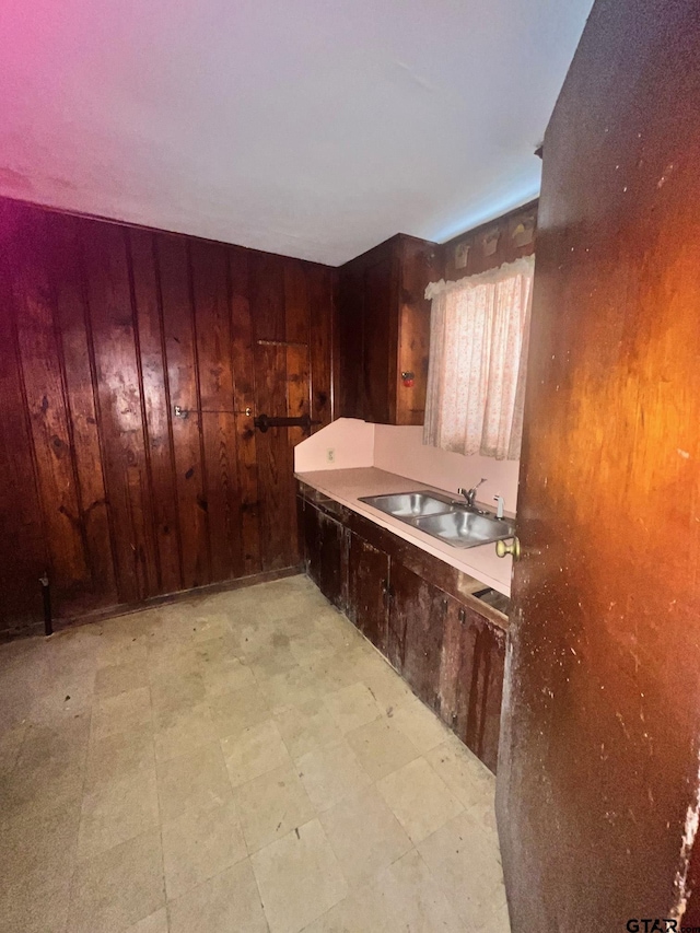 interior space featuring wooden walls, a sink, and light floors