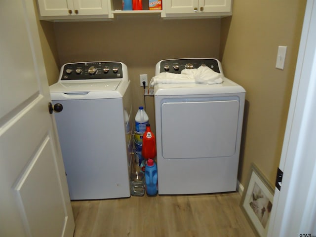 1323 Cummins St, Palestine, TX 75801 - laundry area with washer and dryer, cabinet space, and light wood finished floors