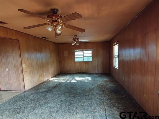 2401 E Fm 852, Winnsboro, TX 75494 - carpeted spare room featuring wooden walls, ceiling fan, and visible vents