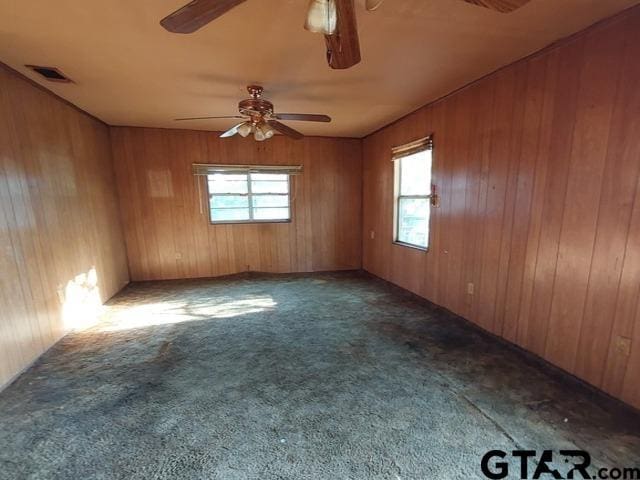 2401 E Fm 852, Winnsboro, TX 75494 - carpeted spare room with visible vents, wood walls, and ceiling fan