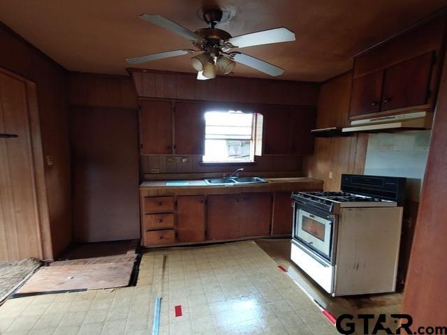 2401 E Fm 852, Winnsboro, TX 75494 - kitchen featuring light floors, ceiling fan, gas range, under cabinet range hood, and a sink