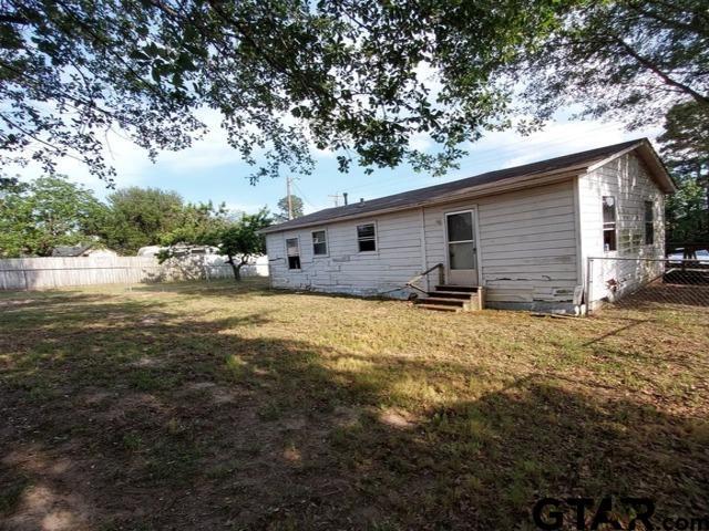 2401 E Fm 852, Winnsboro, TX 75494 - back of house with entry steps, fence, and a lawn