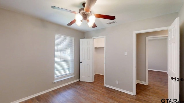 518 Meadow Creek Dr, Tyler, TX 75703 - unfurnished bedroom featuring wood finished floors, multiple windows, a spacious closet, and ceiling fan