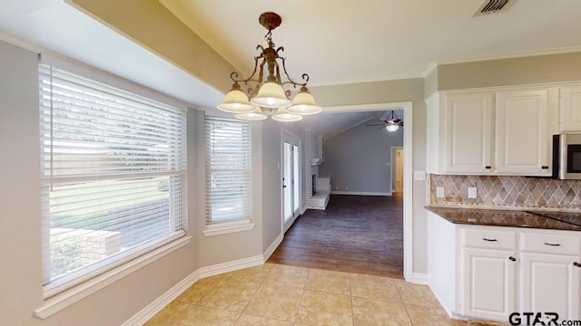 518 Meadow Creek Dr, Tyler, TX 75703 - kitchen with lofted ceiling, a chandelier, white cabinetry, decorative backsplash, and a ceiling fan