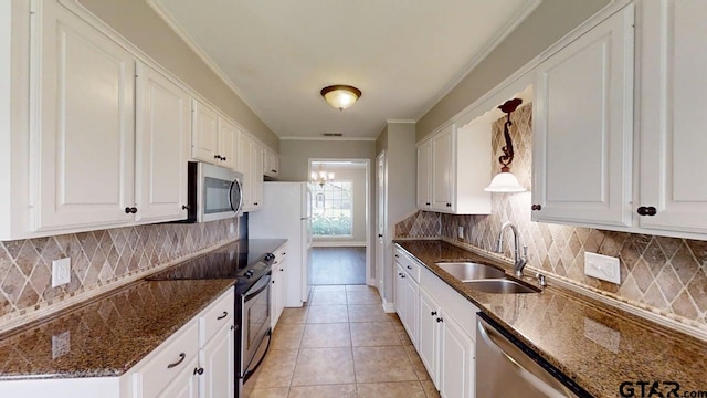 518 Meadow Creek Dr, Tyler, TX 75703 - kitchen with stainless steel appliances, ornamental molding, white cabinets, decorative backsplash, and dark stone countertops