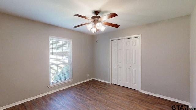 518 Meadow Creek Dr, Tyler, TX 75703 - unfurnished bedroom with multiple windows, dark wood-style floors, a closet, and a ceiling fan