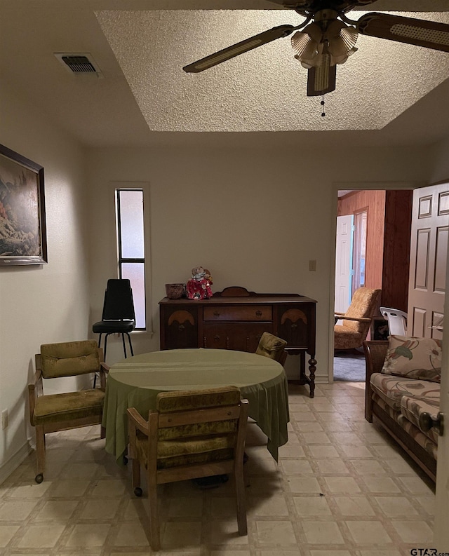 interior space with a textured ceiling and ceiling fan