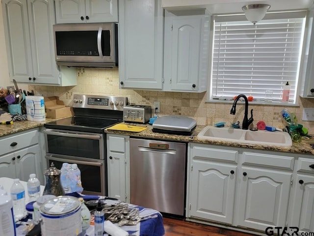 kitchen featuring a sink, white cabinetry, appliances with stainless steel finishes, and backsplash