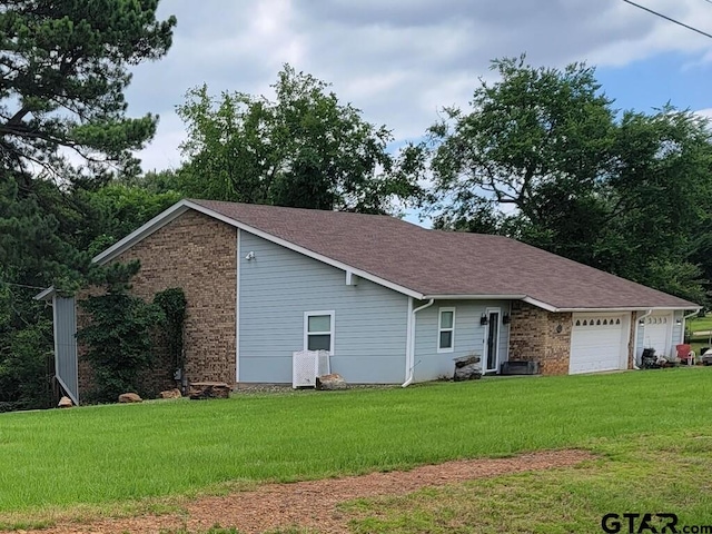 view of front of house with brick siding, a garage, and a front yard