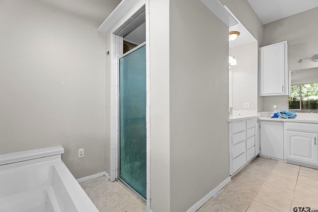 bathroom with tile patterned floors, vanity, and walk in shower