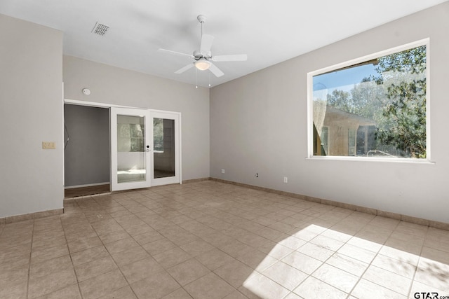 empty room with french doors, ceiling fan, and light tile patterned flooring