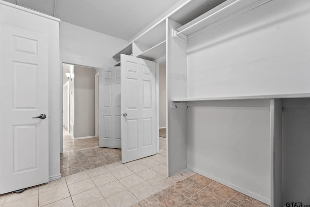 walk in closet with light tile patterned floors