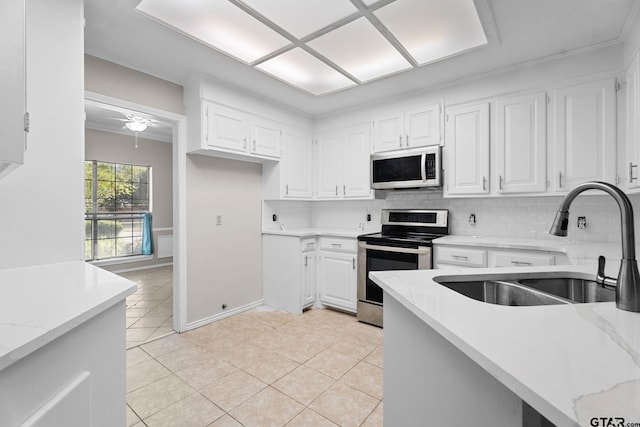 kitchen with stainless steel appliances, white cabinetry, and tasteful backsplash