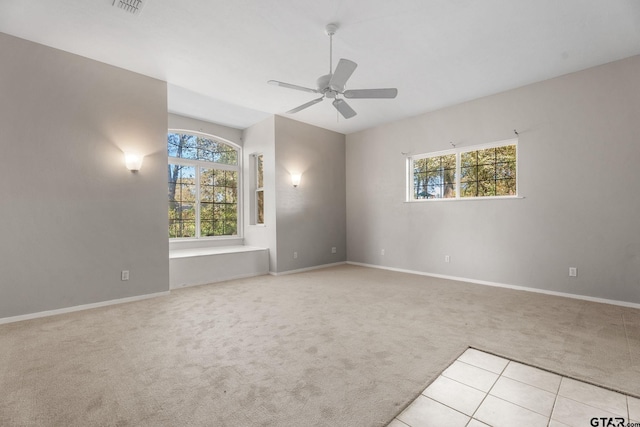 empty room with ceiling fan, light colored carpet, and a healthy amount of sunlight