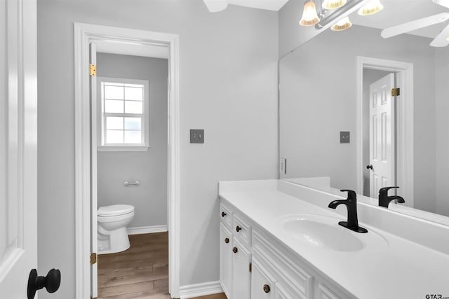 bathroom with toilet, hardwood / wood-style flooring, and vanity