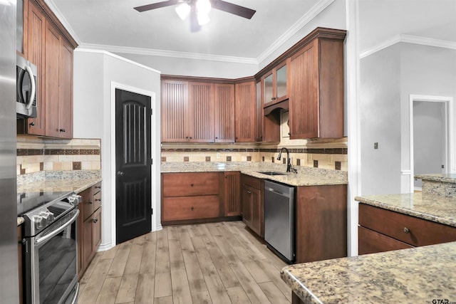 kitchen featuring light stone countertops, appliances with stainless steel finishes, tasteful backsplash, and sink