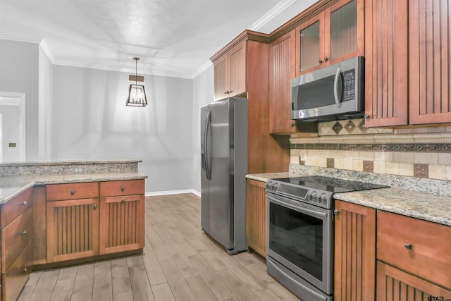 kitchen featuring pendant lighting, stainless steel appliances, light wood-type flooring, light stone counters, and crown molding