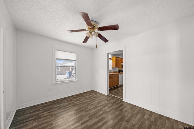 empty room featuring a textured ceiling, ceiling fan, and dark hardwood / wood-style floors