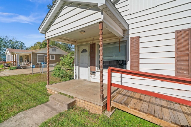 entrance to property featuring a porch and a yard