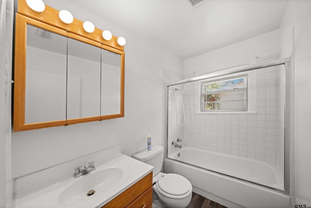 full bathroom featuring hardwood / wood-style floors, vanity, toilet, and tiled shower / bath