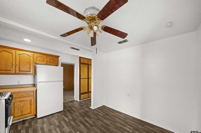 kitchen featuring a textured ceiling, ceiling fan, dark hardwood / wood-style floors, and white appliances