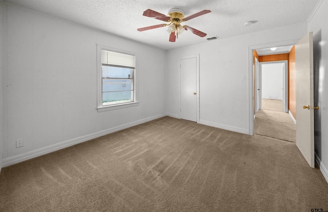 unfurnished bedroom featuring a closet, a textured ceiling, light colored carpet, and ceiling fan