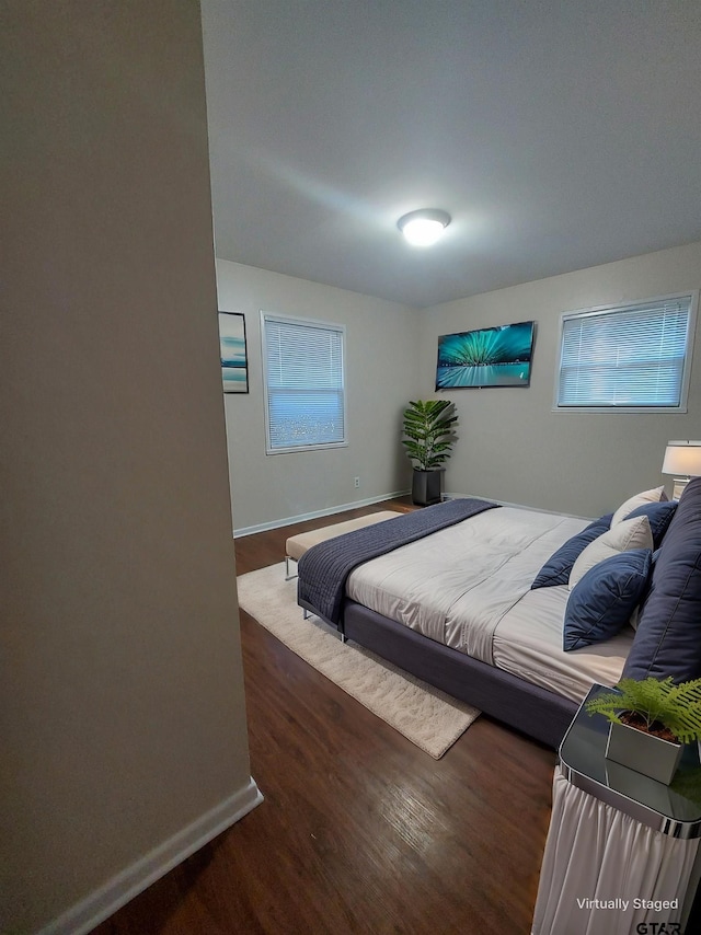 bedroom with dark hardwood / wood-style floors