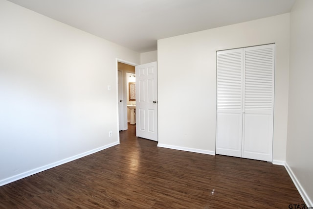 unfurnished bedroom with dark hardwood / wood-style flooring, sink, and a closet