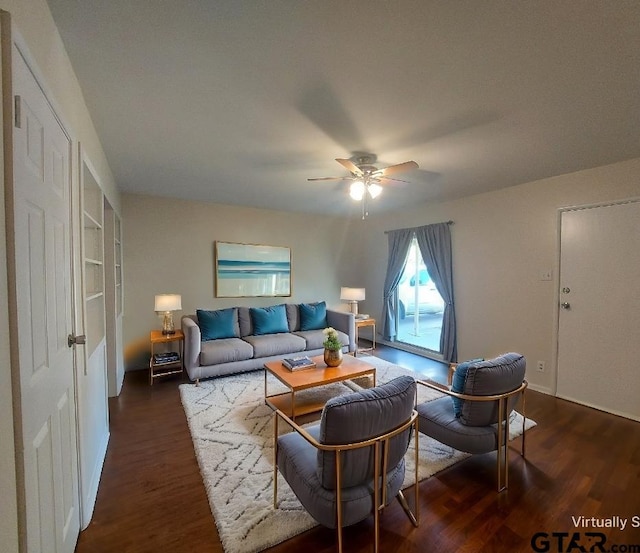 living room featuring ceiling fan and dark wood-type flooring