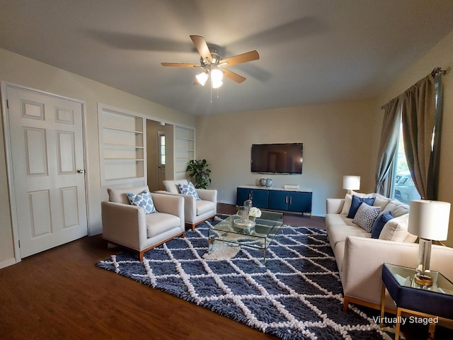 living room with built in shelves, hardwood / wood-style flooring, and ceiling fan