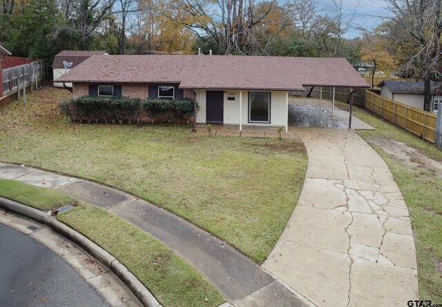 ranch-style home featuring a front lawn and a carport