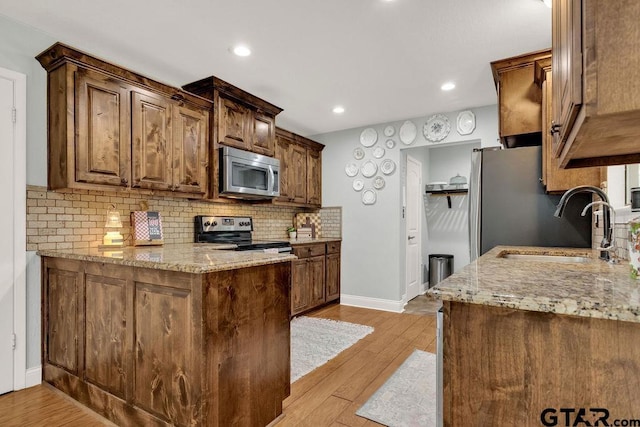 425 Lakeview Dr, Hideaway, TX 75771 - kitchen with stainless steel appliances, a sink, light stone countertops, baseboards, and tasteful backsplash