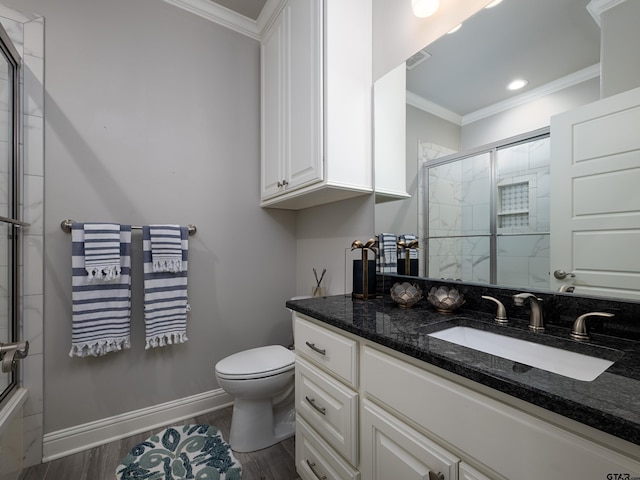 bathroom featuring ornamental molding, wood finished floors, toilet, and baseboards