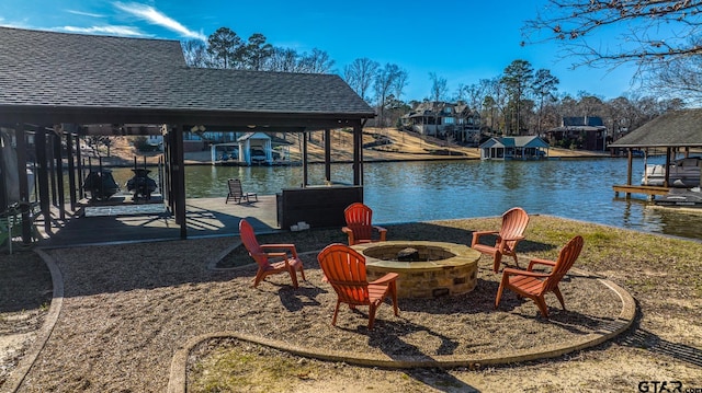 exterior space featuring a water view, a fire pit, and a boat dock