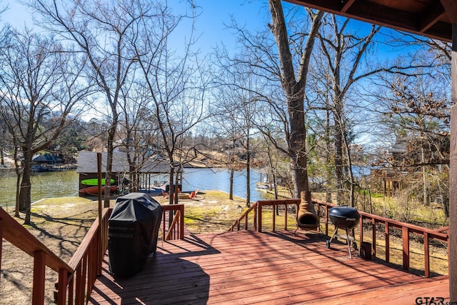 wooden terrace with a water view and grilling area