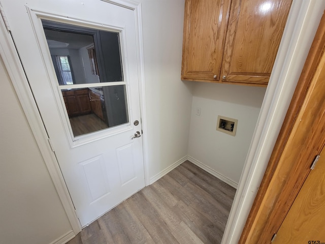 laundry room with washer hookup, cabinets, and light hardwood / wood-style flooring