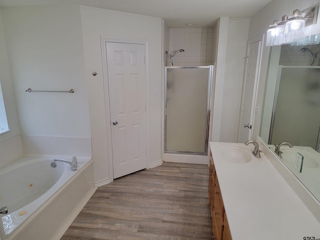 bathroom with hardwood / wood-style flooring, vanity, separate shower and tub, and a textured ceiling