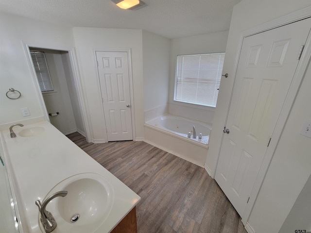 bathroom with a washtub, hardwood / wood-style floors, vanity, and a textured ceiling