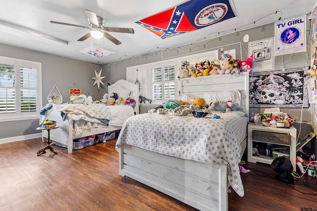 bedroom featuring dark wood-type flooring, multiple windows, and ceiling fan