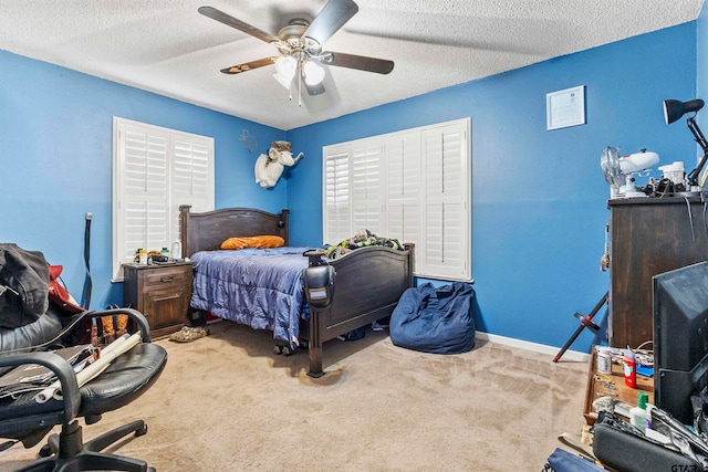 carpeted bedroom featuring ceiling fan and a textured ceiling