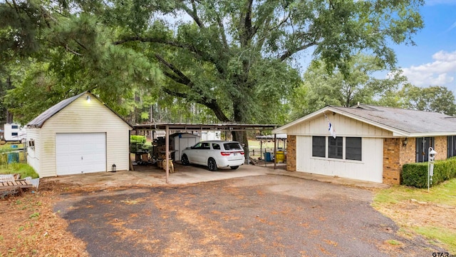 exterior space featuring a garage, an outbuilding, and a carport